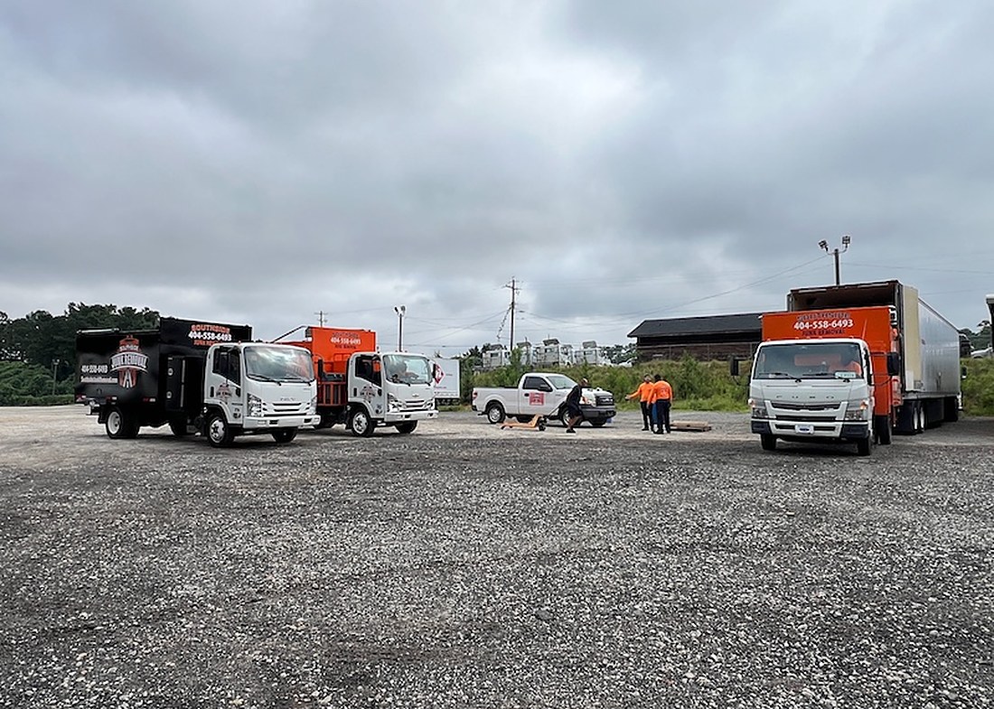 The Southside Junk Removal crew with a branded orange truck in Jonesboro, GA
